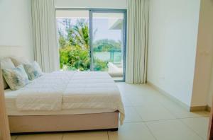a bedroom with a large bed and a large window at Seafront apartment in Grande Gaube +27 photos