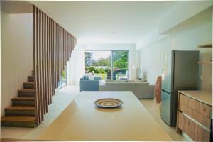 a kitchen with a table and a living room at Seafront apartment in Grande Gaube