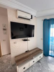 a living room with a large flat screen tv on a wall at Front de mer Chott Mariem in Chott Meriem