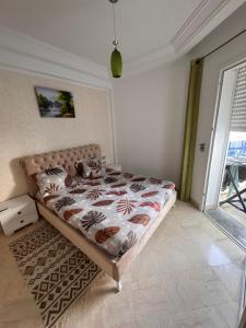 a bedroom with a bed in a room with a window at Front de mer Chott Mariem in Chott Meriem
