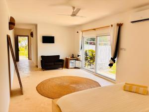 a room with a bed and a chair and a window at Raffia Boutique Hotel in Jambiani