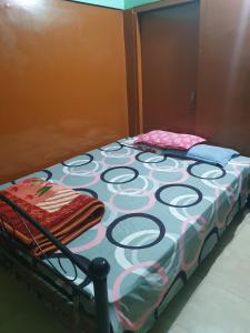 a bed sitting in a room next to a wall at Foothill Lodge in Guwahati +1 photo