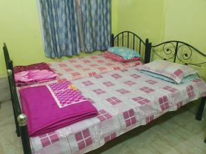 a bed with a blanket and pillows on it at Foothill Lodge in Guwahati