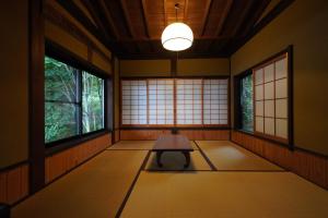 a room with a table and two windows at Yamanoto in Toyooka