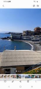 a view of a beach with a building and the ocean at La Casa di Tess in Genoa