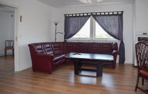 a brown leather couch in a living room with a table at 3 Bedroom Nice Apartment In Sölvesborg in Sölvesborg +9 photos