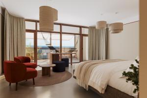a bedroom with a bed and a chair and a desk at King Fisher Village Eco-Boutique Hotel in Tarrafal