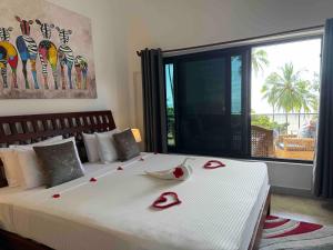 a bedroom with a large bed with red roses on it at MANOLO Beach Resort in Uroa