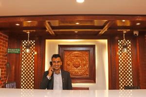Ein Mann telefoniert mit einem Handy. in der Unterkunft Hotel Malati in Kathmandu