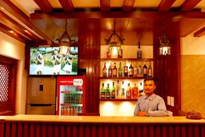 ein Mann, der in einem Restaurant an der Bar sitzt in der Unterkunft Hotel Malati in Kathmandu