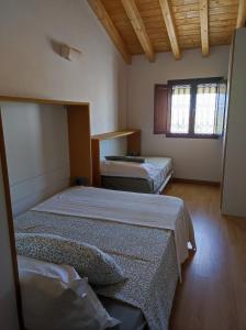 two beds in a room with two windows at Casita in Castrojeriz