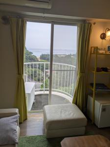 a room with a large window with a view of a balcony at ビーチキャッスルマイウェイ in Shimoda