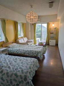 a hotel room with two beds and a chandelier at ビーチキャッスルマイウェイ in Shimoda