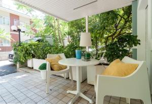 eine Terrasse mit einem weißen Tisch und Stühlen in der Unterkunft Riviera Residence in Rimini