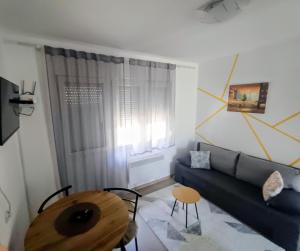 a living room with a couch and a table at Kućica LaMa-Кућица ЛаМа in Mali Mokri Lug