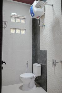 a bathroom with a toilet and a blow dryer at Teras Bumi Cabin in Haurkuning +37 photos
