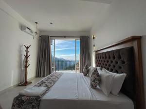 a bedroom with a large bed with a large window at Crystal springs mount face Hotel in Ella