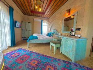 a bedroom with a bed and a vanity and a mirror at Gemosa Cappadocia Hotel in Ürgüp