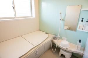 a hospital room with a bed and a mirror at Mansyuya in Isozaki