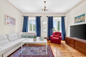 a living room with a white couch and a red chair at VILLA Mara in Dubravka