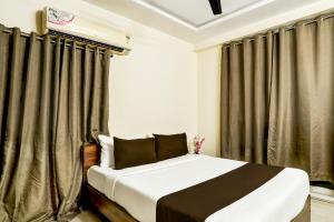 a bedroom with a large bed with curtains at Hotel O Vyb Hotels in Hyderabad