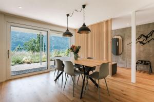 a dining room with a table and chairs at FLORA BAY Spacious Lake and Mountain View Apartment in Niederried