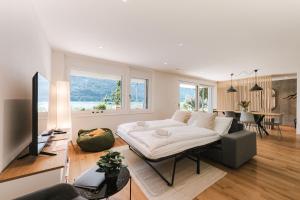 a living room with a white couch and a table at FLORA BAY Spacious Lake and Mountain View Apartment in Niederried