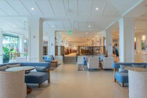 a lobby with blue and white chairs and tables at Exclusive Kauai Beachfront Resort with Dining, Bar, Spa, Pool & Waterslide in Lihue