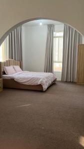 a bedroom with a bed in a room with an oval mirror at Khalifa A Apartement V15 in Abu Dhabi +1 photo