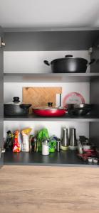 a kitchen shelf with pots and pans on it at Apartments in Bălţi +9 photos
