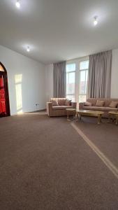 a large living room with couches and tables and windows at Khalifa A Apartement V15 in Abu Dhabi