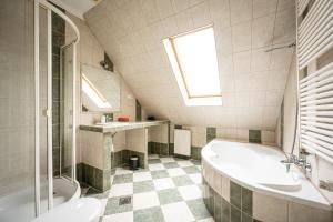 a bathroom with a tub and a toilet and a sink at Gere Apartment de Luxe in Harkány +7 photos