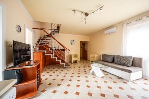 a living room with a couch and a tv at Gere Apartment de Luxe in Harkány