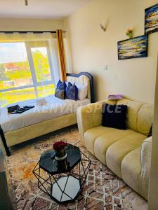 a living room with a couch and a bed at Bohen BnB 2 in Ongata Rongai 
