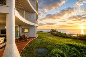 a building with a view of the ocean at sunset at Chakas Cove in Ballito
