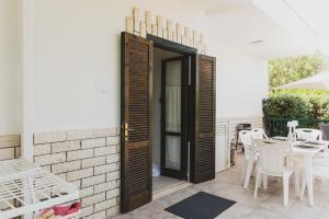 a patio with a table and chairs and a door at Villa Zoe in Specchiolla