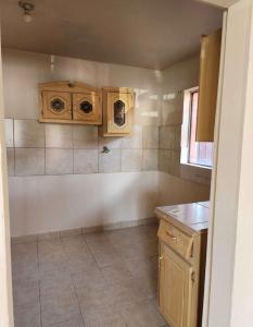 eine Küche mit Holzschränken und Fliesenboden in der Unterkunft Casa Joan in El Sauzal