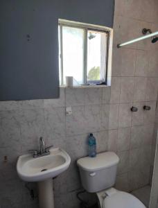 ein Badezimmer mit Waschbecken, Toilette und Fenster in der Unterkunft Casa Joan in El Sauzal