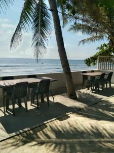 a table and chairs on a beach with the ocean at Pacific View Point in Matnog