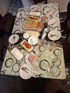 a table with plates and glasses and food on it at Guest House Batumi in Batumi
