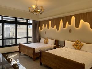 a hotel room with two beds and a chandelier at 好客來-正市區電梯別墅步行東大夜市3分鐘公正包子1分鐘 in Hualien City