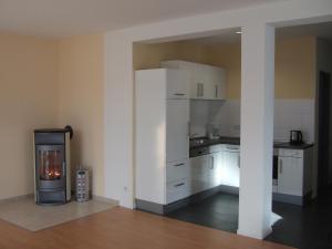 a kitchen with white cabinets and a fireplace in it at Ferienhaus Lutowsee in Grammertin