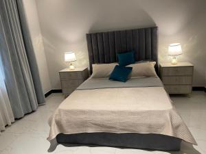 a bedroom with a large bed with blue pillows at Bellwether Heights Kyanja in Kampala