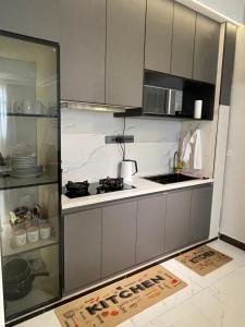a small kitchen with a stove and a microwave at Bellwether Heights Kyanja in Kampala