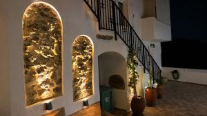 a hallway with three arched windows and a staircase at Aethra Seaview Suites in Kerames