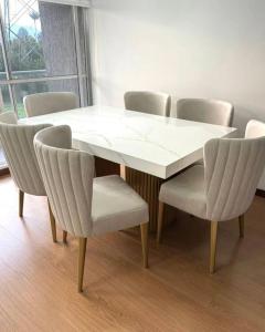 a white dining table and chairs with a white table and chairsktop at Ste hub loges in Parakou