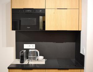 a kitchen with a black microwave and a coffee maker at Moravská 15 Apartments in Karlovy Vary
