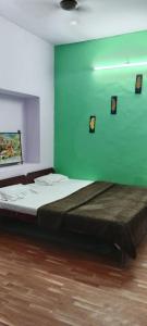 a bedroom with a bed with a green wall at Hotel Raj Bed And Breakfast in Agra