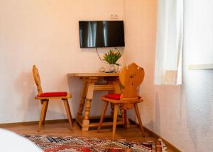 a room with two chairs and a table with a television at Ferienwohnungen Vomperberg in Schwaz