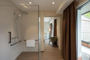 a bathroom with a shower and a glass door at Hotel Safiro in Fluelen +28 photos